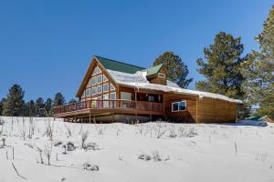 una baita di tronchi nella neve con alberi di Mountain Home with Deck 1 Mi to Angel Fire Resort! ad Angel Fire