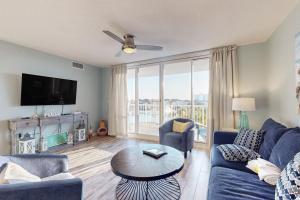a living room with a blue couch and a large window at The Terrace at Pelican Beach 304 in Destin