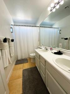 a bathroom with a sink and a toilet and a mirror at Vegas Getaway, Pool, Basket Ball, Games, Cook in Las Vegas