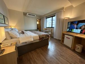 a hotel room with a bed and a flat screen tv at Lets Idea Brasilia Hotel - Flat Particular in Brasília