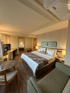 a hotel room with a large bed and a table at Lets Idea Brasilia Hotel - Flat Particular in Brasilia