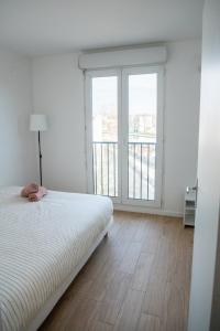 聖但尼的住宿－Spacieux - Idéal JO 2024 - Stade de France - Paris，一间卧室设有一张床和一个大窗户