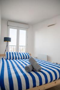 聖但尼的住宿－Spacieux - Idéal JO 2024 - Stade de France - Paris，一间卧室配有一张蓝色和白色条纹的床
