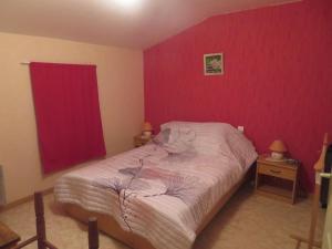 a bedroom with a bed and a red wall at Gite Les hippocampes in Saint-Germain-de-Marencennes