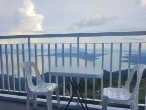 two chairs and a table on a balcony with a view at Blowing In The Wind in Tagaytay