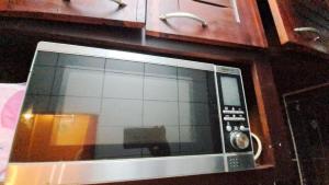 un horno microondas sentado en la parte superior de un mostrador en Residence GermanoTech, Bonamoussadi,Logbessou appartement meublé 2ch,1salon eau chaude,Wifi,parking,virgile,menagere,canalsat, en Douala