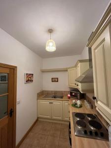 uma cozinha com um lavatório e um fogão forno superior em Minnie’s Cottage 