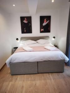 een slaapkamer met een bed met twee foto's aan de muur bij La promesse - T2 Hyper centre in Abbeville