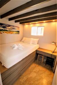 ein großes Bett in einem Zimmer mit einem Schreibtisch in der Unterkunft Exotic Sukiya Tiny House Japanese Balinese Gardens in Homestead