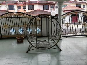 une chaise assise sur un balcon avec une clôture dans l'établissement Muar 6 Bedrooms Semi-D With Security Guard Homestay 15-20pax, à Muar