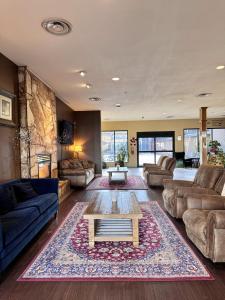 a living room with couches and a coffee table at Divya Sutra Plaza and Conference Centre, Vernon, BC in Vernon