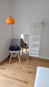 a living room with a chair and a lamp at Ferienwohnung AS5 One Bamberg - ruhig, zentral mit Balkon in Hallstadt