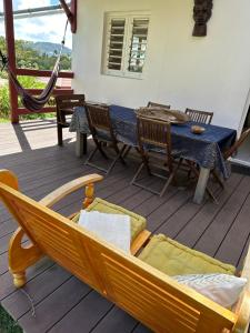 a hammock and a table and chairs on a deck at Kama in Sainte-Luce