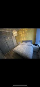 a bedroom with a white bed and a chandelier at Town centre apartment in Motherwell