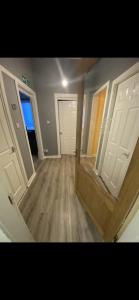 an empty room with two doors and wooden floors at Town centre apartment in Motherwell