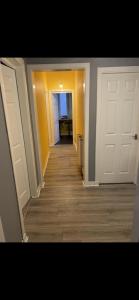 a hallway with two white doors and a wooden floor at Town centre apartment in Motherwell