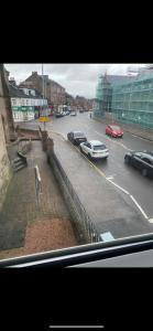 a view of a city street with cars on the road at Town centre apartment in Motherwell