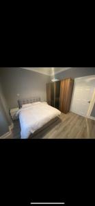 een slaapkamer met een groot wit bed. bij Town centre apartment in Motherwell
