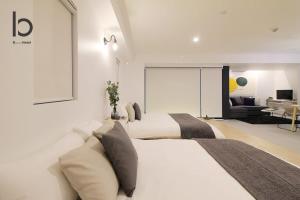 1 dormitorio con 2 camas y sala de estar en bHOTEL Heiwaoodori 102 - Beautiful New 1BR Apartment for 6 ppl, en Hiroshima