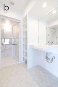 a white bathroom with a sink and a shower at bHOTEL Heiwaoodori - Beautiful New 1BR Apartment for 6 ppl in Hiroshima