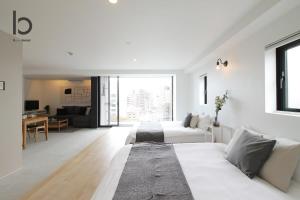 Sala de estar blanca con cama y sofá en bHOTEL Heiwaoodori 901 - New Apt in Famous Hiroshima Dori For 6p, en Hiroshima