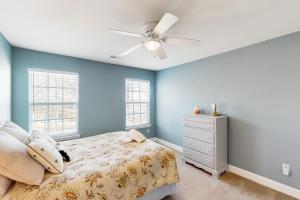 una camera da letto con pareti blu, un letto e un ventilatore a soffitto di Poppy's Playhouse a Mineral