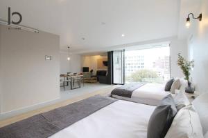 1 dormitorio con 2 camas y sala de estar en bHOTEL Heiwaoodori 601 - New Apt In Famous Hiroshima Dori For 6p, en Hiroshima
