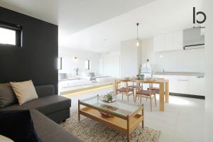 a living room with a couch and a table at b hotel Heiwaodori 1001 - Brand new Apt Famous Hiroshima dori 6p in Hiroshima