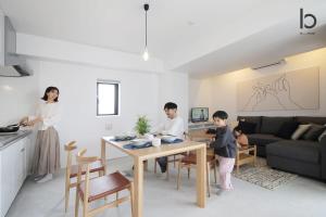 a family in a living room with a table at b hotel Heiwaodori 1001 - Brand new Apt Famous Hiroshima dori 6p in Hiroshima