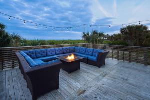 a patio with a blue couch and a fire pit at Hilton Cocoa Beach Oceanfront in Cocoa Beach