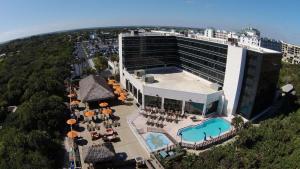 an aerial view of a hotel with a pool and patio at Hilton Cocoa Beach Oceanfront in Cocoa Beach