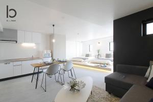 広島市にあるb hotel Heiwaodori 602 - Huge Apt in Famous Hiroshima Dori for 6pのソファとテーブルのあるキッチンとリビングルーム