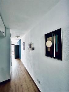 un pasillo con una pared blanca con una foto. en Sasha Tenerife, en Costa del Silencio