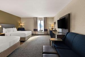 um quarto de hotel com duas camas e um sofá em Comfort Inn Huntington Near University em Huntington