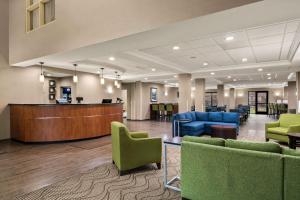 a lobby with green chairs and a waiting room at Comfort Suites Hummelstown - Hershey in Hummelstown