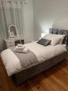 een slaapkamer met een bed met een spiegel en een dressoir bij Fair Green B&B in Ballygawley