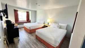 una camera d'albergo con due letti e una finestra di Microtel Inn & Suites by Wyndham Gallup - PET FRIENDLY a Gallup