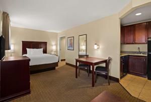 a hotel room with a bed and a desk at MainStay Suites Houma in Houma