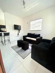 ein Wohnzimmer mit einem Sofa und einem Tisch in der Unterkunft Casa em Natal /Extremoz - RN in Extremóz