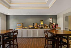 a restaurant with two tables and a counter at MainStay Suites Houma in Houma
