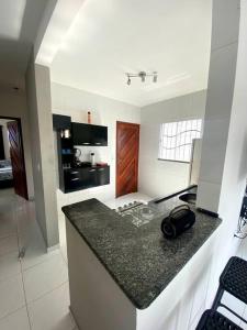 eine Küche mit einer schwarzen Arbeitsplatte in einem Zimmer in der Unterkunft Casa em Natal /Extremoz - RN in Extremóz