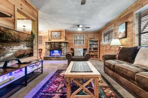 sala de estar con sofá y chimenea en The Eagle's Nest Mountain Cabin Gatlinburg en Gatlinburg