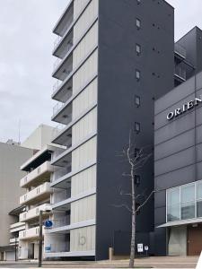 een kantoorgebouw met een bord erop bij b hotel Heiwaodori 201 - New Apt in Famous Hiroshima Dori Max 6p in Hiroshima +22 foto's