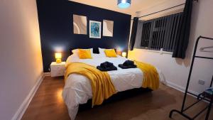 a bedroom with a large bed with yellow pillows at Stunning Cosy 2 Bedroom Flat with Parking, Central in Birmingham