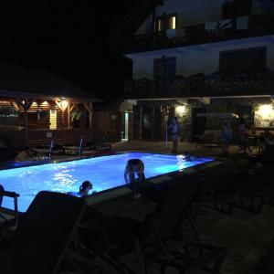 a group of people in a swimming pool at night at Németh Resort in Sovata