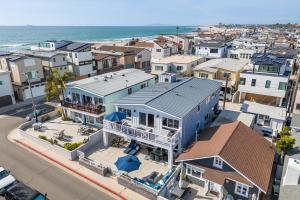 an aerial view of a city with houses and the ocean at Ocean Breeze I by AvantStay Steps to the Beach in Newport Beach