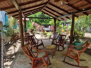 un grupo de sillas sentadas bajo una pérgola de madera en Ometepe House, en Moyogalpa