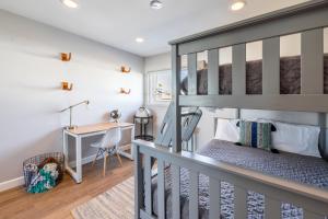 a bedroom with a bunk bed and a desk at Ocean Breeze II by AvantStay Steps to the Beach in Newport Beach