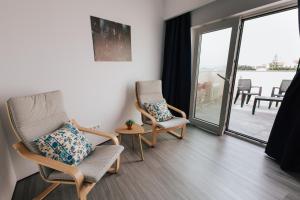 een woonkamer met 2 stoelen en een balkon bij Penthouse Seaside Apartment B - Faraway in Lagoa