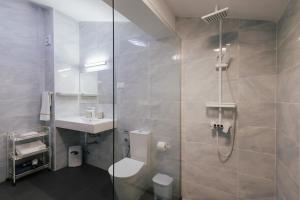 a bathroom with a shower and a toilet and a sink at Penthouse Seaside Apartment B - Faraway in Lagoa
